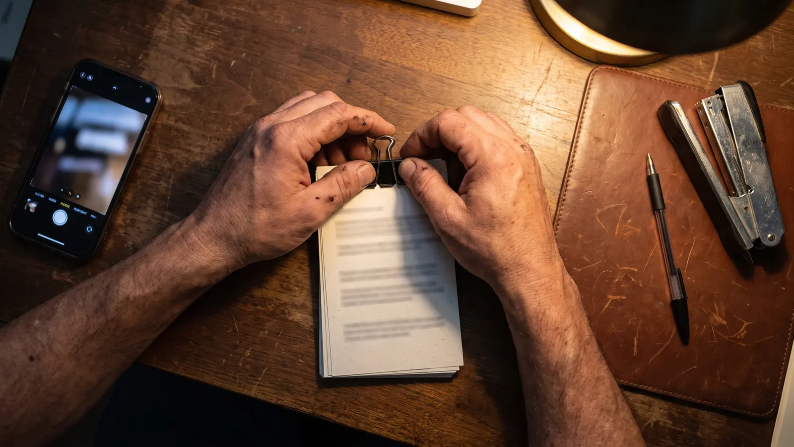 The Flow of the Load: delivered isn't done until it funds Carrier's hands clipping a stack of load paperwork into one packet on a wooden desk