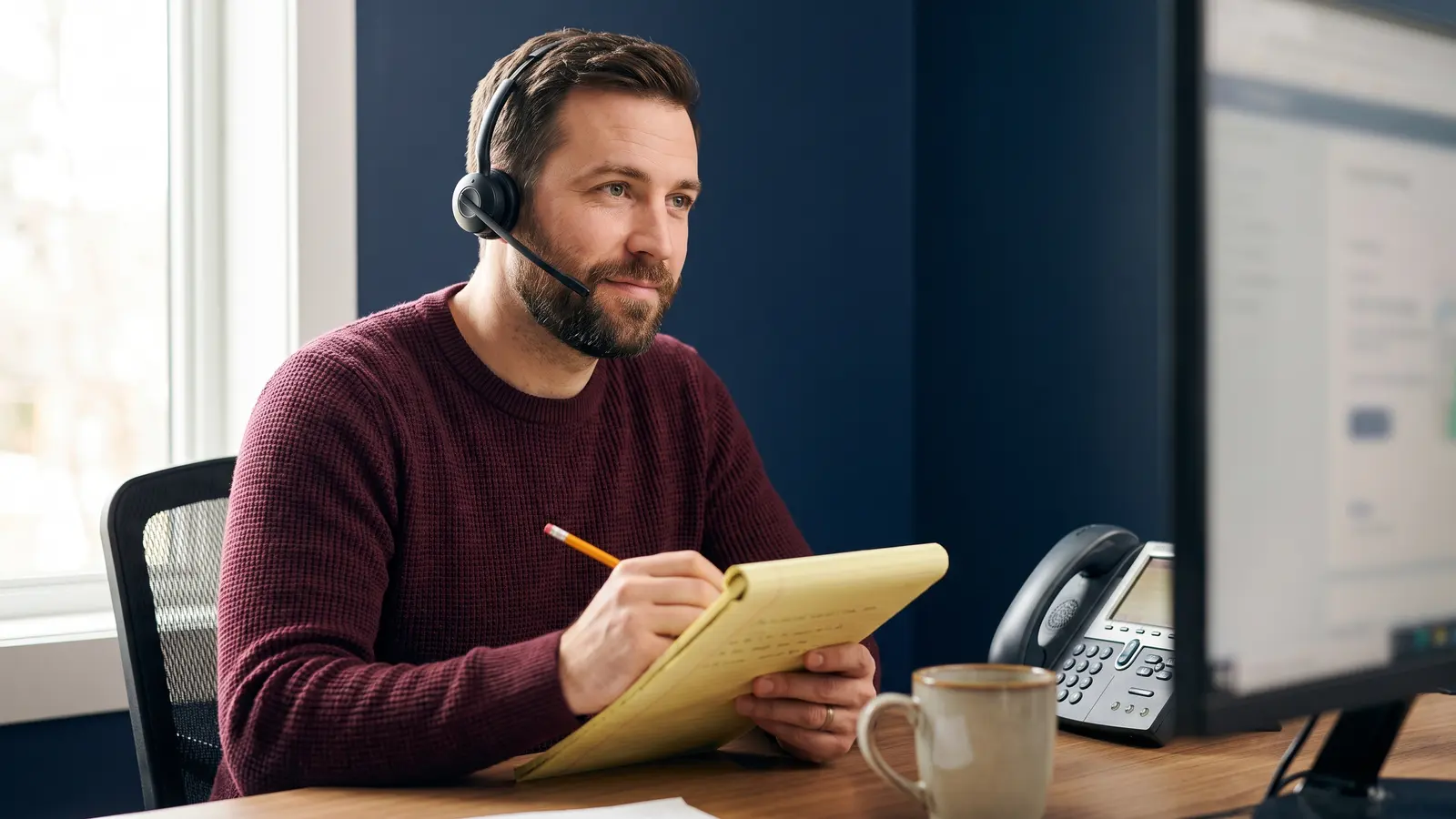 How PLSP students learn to broker freight Freight agent trainee on a headset negotiating a load rate with a carrier and taking notes